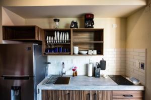 una cocina con nevera de acero inoxidable y armarios de madera en Casa de la Ballena, en Sayulita