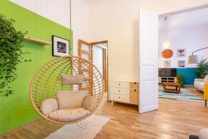 une chambre avec une chaise en rotin dans le salon dans l'établissement Live Star Apartment, à Budapest