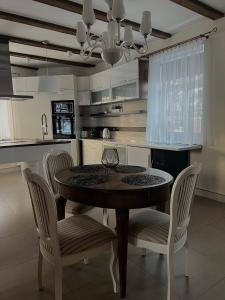 a kitchen with a wooden table and chairs in a kitchen at Boutique Guest House in Liepāja