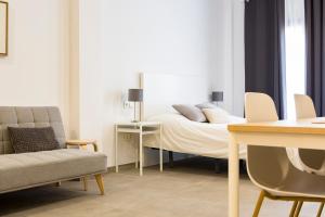 Schlafzimmer mit einem Bett, einem Tisch und Stühlen in der Unterkunft Apartamento Málaga Marmoles 2 in Málaga