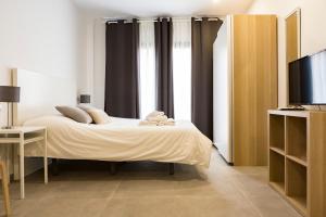 sypialnia z łóżkiem i telewizorem w obiekcie Apartamento Málaga Marmoles 2 w Maladze