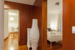 Zimmer mit einem Schlafzimmer mit einem Kinderbett und einem Spiegel in der Unterkunft FLH Expo Cozy Apartment in Lissabon