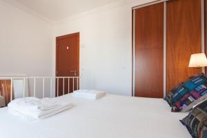 ein Schlafzimmer mit einem Bett mit Handtüchern darauf in der Unterkunft FLH Expo Cozy Apartment in Lissabon