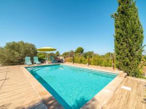 una piscina con una terraza de madera y una sombrilla en Villa Can Lloret, en Algaida