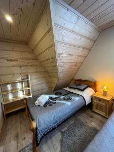 a bed in a room with a wooden ceiling at Apartamenty Smrekowka in Zakopane