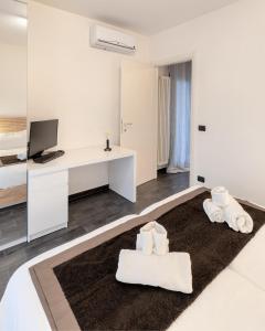 Habitación blanca con escritorio y toallas en Casa Massima Suite 4, en Casamassima