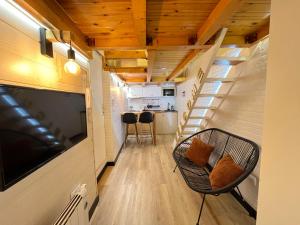 a living room with a couch and a television and stairs at Mini duplex plaza mayor in Madrid