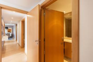 a hallway with a wooden door and a kitchen at FLH Expo Apartment with View in Lisbon