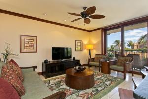 a living room with a couch and a flat screen tv at Ko Olina Beach Villas O410 - 2BR Luxury Condo with Partial Ocean View in Kapolei