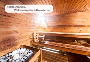 a sauna with wooden walls and a wooden table at Hotel Lenzerhorn in Lenzerheide