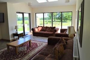 Sala de estar con 2 sofás y mesa en The Farmhouse at Williamscraig Holiday Cottages, en Linlithgow
