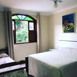 a bedroom with a bed and a window at Pousada & Eventos Casa do Jova - Raposo RJ in Raposo +35 photos