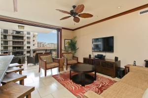 a living room with a tv and a table and chairs at Ko Olina Beach Villas O512 - 2BR Ocean View Luxury Condo with Semi-Private Lagoon Beach & 1 Free Parking in Kapolei