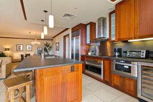 a kitchen with wooden cabinets and a counter top at Ko Olina Beach Villas O512 - 2BR Ocean View Luxury Condo with Semi-Private Lagoon Beach & 1 Free Parking in Kapolei