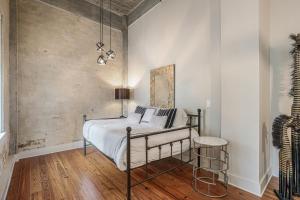 um quarto com uma cama com paredes brancas e pisos em madeira em 2 Bedroom Elegant condos in Downtown New Orleans em Nova Orleães