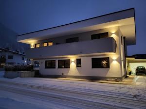 a white house with lights on the side of it at Apart Isabella in Schwendau