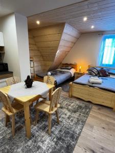 una camera con due letti e un tavolo con sedie di Apartamenty Smrekowka a Zakopane