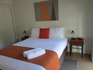 a bed with a white comforter and pillows at Breezes Apartments in Broome