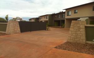 a large brick building with a stone wall at Breezes Apartments in Broome