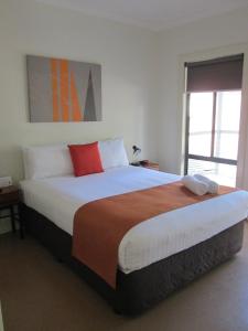 a bedroom with a large bed with two towels on it at Breezes Apartments in Broome