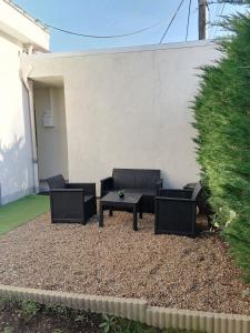 een patio met stoelen en een tafel in de tuin bij Studio meublée avec sanitaires douche kitchenette in Angers