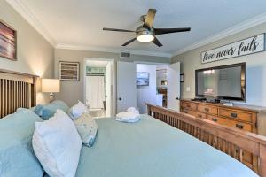 a bedroom with a bed and a flat screen tv at Sunlit St Petersburg Condo with Community Pool in St Petersburg +22 photos