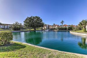 a large pool of water in a yard with houses at Sunlit St Petersburg Condo with Community Pool in St Petersburg