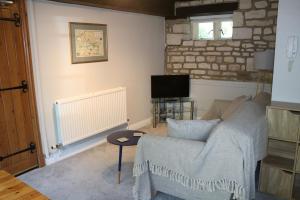 a living room with a couch and a tv at Flat 2 - The Old Mill - Bowbridge Lock - Stroud in Stroud