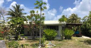 a small green house with trees and plants at Moana Breeze Eco Lodge Rangiroa in Tiputa