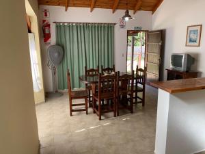 cocina y comedor con mesa y sillas en Cabañas Costa Vergel en Los Reartes
