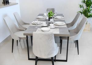 a dining room table with white chairs around it at Live close to Lagoons Canal - 1 BR Apartment in Ras al Khaimah +12 photos