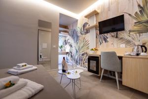 ein Wohnzimmer mit einem Sofa und einem Schreibtisch mit einem TV in der Unterkunft Sentido Michelizia Tropea Resort in Tropea