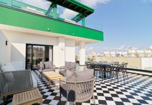a patio with chairs and tables on a checkered floor at Maestro St Lazar Apartments in Larnaca