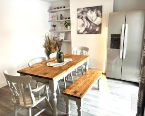 uma mesa de jantar com cadeiras e um frigorífico em Lovely Single Room em Hither Green