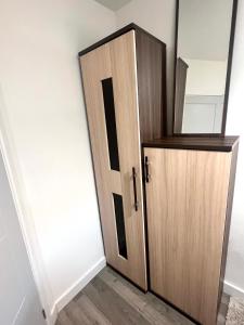 uma porta de madeira no canto de um quarto em Lovely Single Room em Hither Green