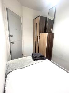 ein Schlafzimmer mit einem Bett mit einem Spiegel und einer Kommode in der Unterkunft Lovely Single Room in Hither Green
