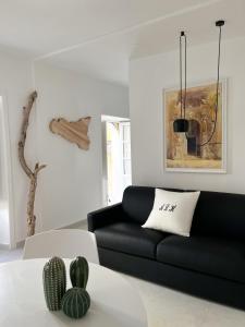 uma sala de estar com um sofá preto e uma mesa em Artemide Luxury Home em Siracusa