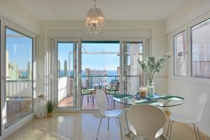uma sala de jantar com mesa e cadeiras e uma varanda em Playa Postiguet Penthouse by NRAS em Alicante