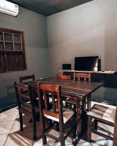 - une salle à manger avec une table, des chaises et un piano dans l'établissement Hostel 420, à Parati