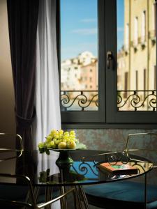 a table with a plate of grapes in front of a window at Madama Garden Retreat in Venice