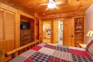 Dormitorio con cabaña de madera, cama y TV en Cascade Escape, en Fleetwood