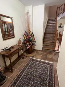 Sala de estar con mesa, alfombra y escaleras en Cal Cuaresma en Isona