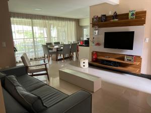 a living room with a couch and a tv at Manhattan Beach Riviera in Aquiraz