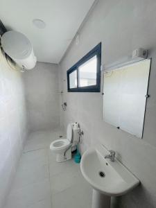 a white bathroom with a toilet and a sink at Appart Hôtel Pyramides El Jadida in El Jadida