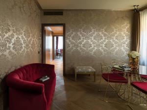 salon z czerwoną kanapą i stołem w obiekcie Madama Garden Retreat w Wenecji