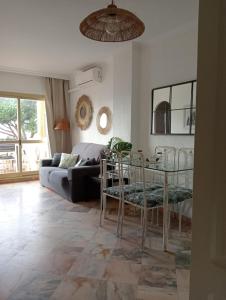 uma sala de estar com um sofá e uma mesa em Romana Playa 132 Apartment by GHR Rentals em Marbella