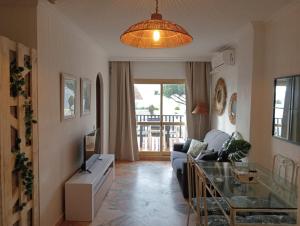 uma sala de estar com um sofá e uma mesa de vidro em Romana Playa 132 Apartment by GHR Rentals em Marbella