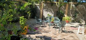 a patio with chairs and a table and some plants at Casita de las flores in San José de Ocoa