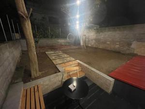 a room with a table and a bench and a table and a stool at Central cozy apartment with garden in Alexandroupoli
