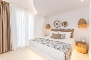 a white bedroom with a bed and a large window at Nikos & Maria Apts - Suites in Plaka